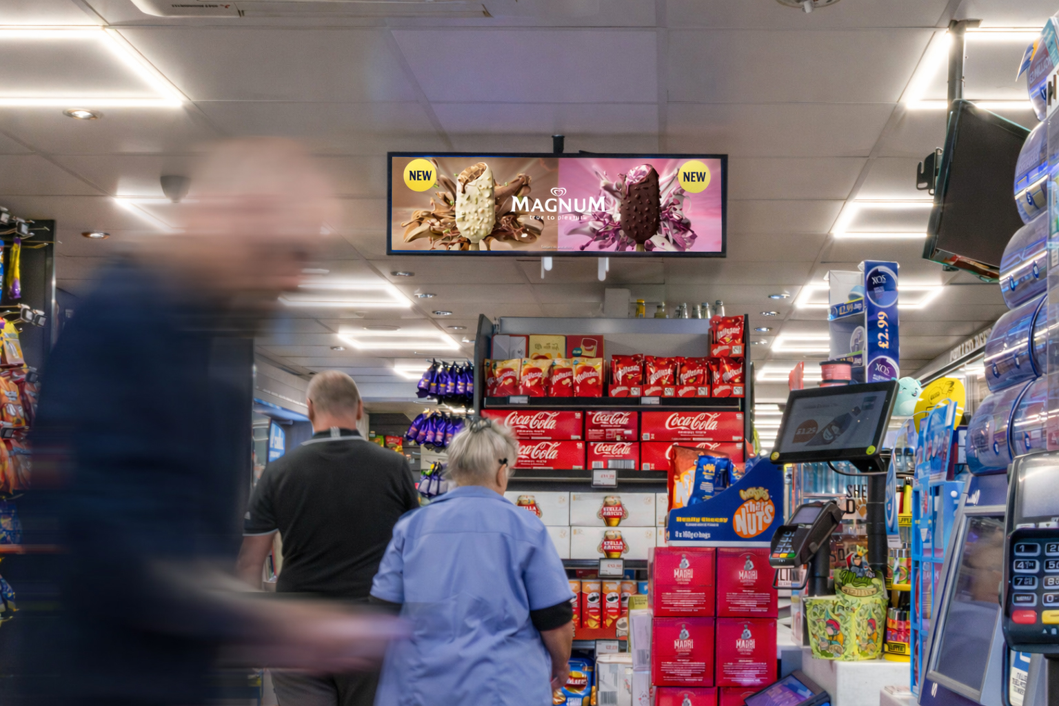 Checkout and point-of-sale advertising screens inside a supermarket influencing last-minute purchase decisions