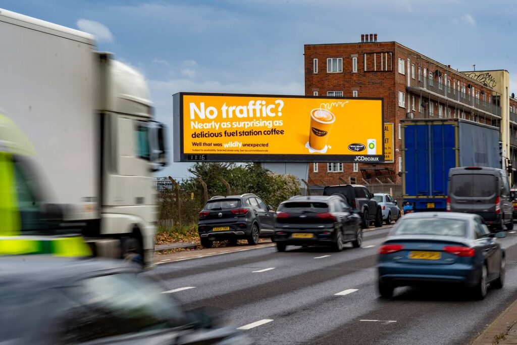 Automotive out-of-home advertising campaign visible in busy city traffic