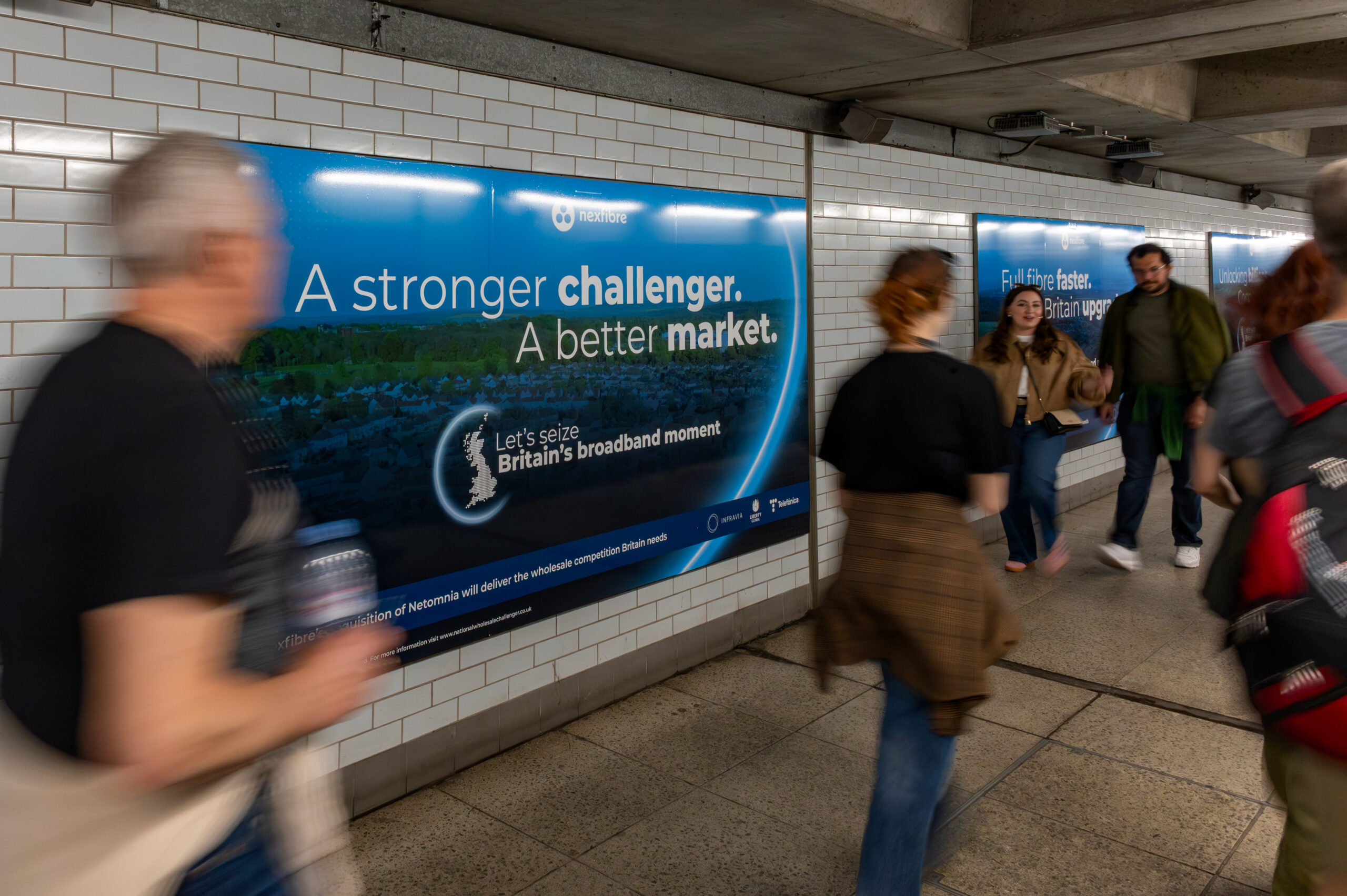 Commuters passing London Underground domination OOH